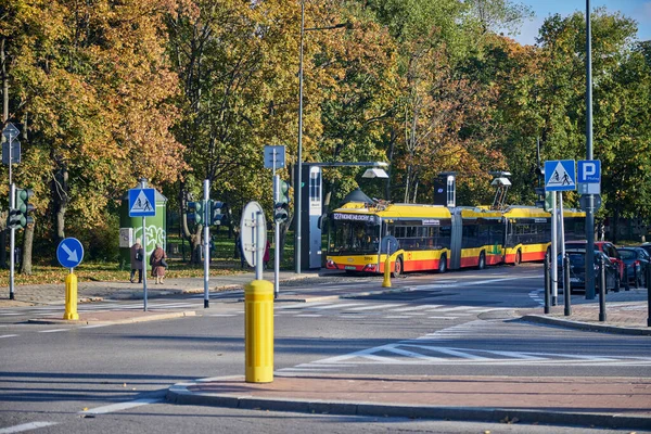 Modern trolley bus riding with passengers in the streets of Warsaw.