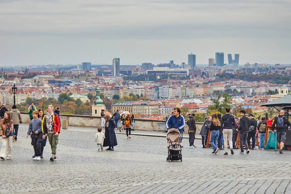 An observation deck on Prague with a view of the autumn city of Prague and people on it.