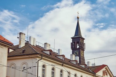 Clock on church tower in Prague against the sky.