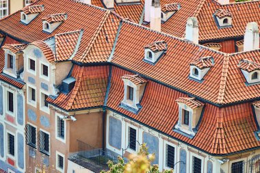 Orange tile roofs view and historical buildings in touristic Prague.