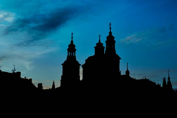 Silhouette of Prague old town Square church against the sky.