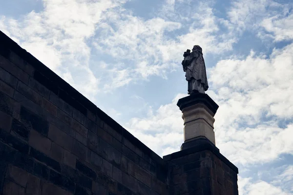 Statue on Charles Bridge in Prague against the sky.