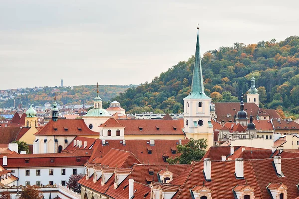 Orange tile roofs and church view, and historical buildings in Prague.