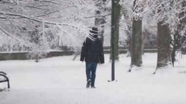 Boy walking in the snowy park under the snow in Krakow, Poland. Slow motion video.