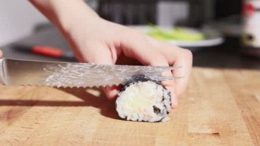 Tahta kesme tahtasının üzerinde rulo kesen çocuk. Yavaş çekimde video.