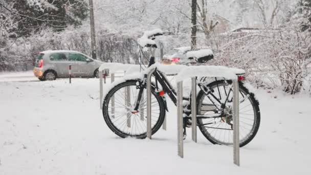 Czarny Rower Pod Padającym Śniegiem Przy Drodze Poruszającymi Się Samochodami — Wideo stockowe