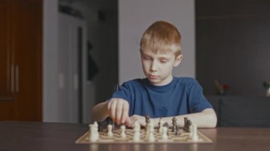 The boy thinks about the move and makes it in the chess.