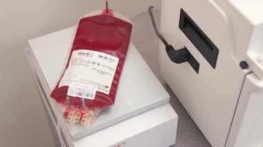 Mixing blood in a container in laboratory using special medical equipment.