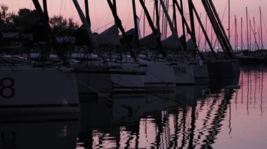 Slovenya 'daki Izola yat marinasında yat marinasında gün batımı. Bir sürü yelkenli ve gemi direği.