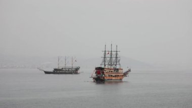 Direkleri olan iki eski ahşap korsan gemisi Türkiye 'de sakin denizde yelken açıyor.