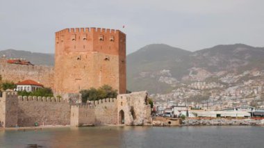 Türkiye 'nin Alanya kentindeki sudan görüldüğü gibi Kızıl Kule. Türk kentinde tarihi kule Kizil Kule ve Alanya Etnoğrafya Müzesi de kulenin içinde.