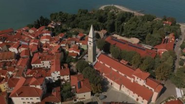 Slovenya, Izola 'nın daire manzarası. Kırmızı kiremitli çatısı ve saat kulesi olan tarihi binalar.