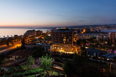 Türkiye 'de gün batımında Avsallar kenti manzarası ve turistli oteller.