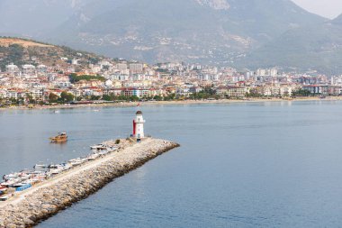 Türkiye 'nin Alanya kentindeki su ve manzara manzarası boyunca yürüyüş için resim gibi bir yerde küçük bir deniz feneri. Deniz feneri şehrin limanında duruyor..