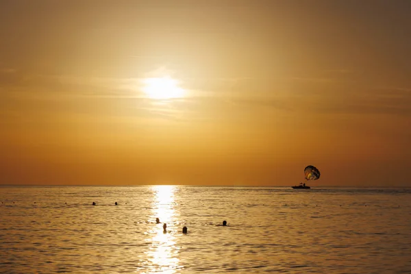 Türkiye 'de insanlar gün batımında denizde yüzüyor.
