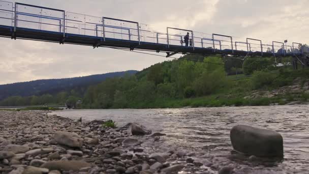 Most Wiszący Nad Rzeką Matka Spaceruje Nim Dzieckiem Rowerem — Wideo stockowe