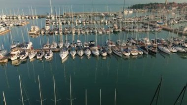 Slovenya 'da Izola' da büyük marina altında bir sürü tekne ve direkle uçmak.