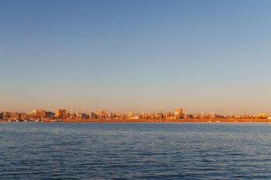 Günbatımında Torrevieja limanına demirlemiş yelkenli yelkenlilerin direkleri, panoramik manzara.