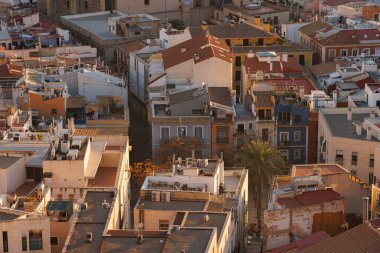 Alicante 'de doğan güneşin yumuşak ışığında eski evler ve çatılar.