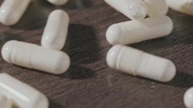 Tabletler masaya dökülüyor. Eczane için harika bir geçmiş. Yavaş çekim 4k video.