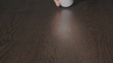 Beyaz kapsüller kavanozdan masaya yavaş çekimde dökülüyor..