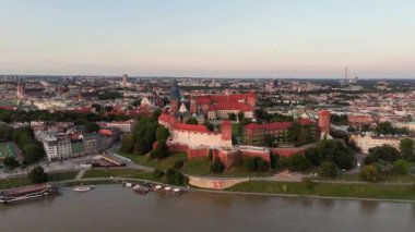 Krakow Kraliyet Wawel 'ı gün batımında. İnsansız hava aracı Vistula Nehri 'nden yaklaşıyor. Hava görüntüsü.