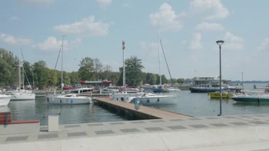 Gizycko 'da iskeleye yanaşmış yatlarla dolu canlı bir marina. Sahne, Polands Masurian Lake District 'in canlı atmosferini gözler önüne seriyor. Tekne meraklıları için mükemmel..