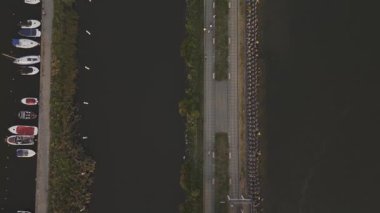 Gün batımında Gizycko rıhtımının üzerinde güzel bir insansız hava aracı var. Altın ışık gezinti güvertesini, marinayı ve kasaba binalarını yıkar, sıcak ve sakin bir atmosfer yaratır..