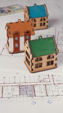 Minyatür ev modellerinin yer aldığı mimari planlara çok sayıda avro banknot yerleştirildi. Dikey kompozisyon, gayrimenkul yatırımı ve emlak alımı kavramını ortaya koymaktadır..