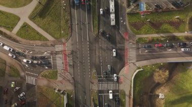 Kamera yükselirken Polonya, Krakow 'daki yoğun bir kavşağın insansız hava aracı görüntüleri. Açık sokaklar ve yeşilliklerle dolu bahar atmosferi canlı şehir yaşamını vurguluyor..