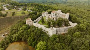 Polonya 'daki Tenczyn Kalesi' ni çevreleyen hava aracı görüntüleri ortaçağ kalesini her açıdan gösteriyor. Manzara taş duvarları, kuleleri ve çevreleyen manzaraları vurguluyor..