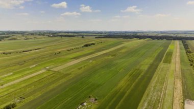 Renkli çizgili desenli tarımsal alanlara geniş bir hava manzarası, kırsal alanda ekilmiş tarım arazisinin güzelliğini ve düzenini gözler önüne seriyor..