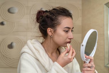 Güzel manken banyoda çekim yapmaya ve makyaj yapmaya hazırlanıyor. Makyaj konsepti.