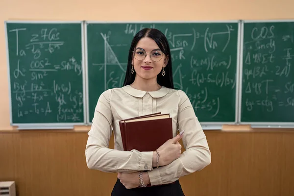 教室で数式を使った黒板に対する若い女性教師の肖像画です 教育の概念 — ストック写真