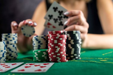 Dişi el poker masasında poker fişleri topluyor. Riskli bahisler