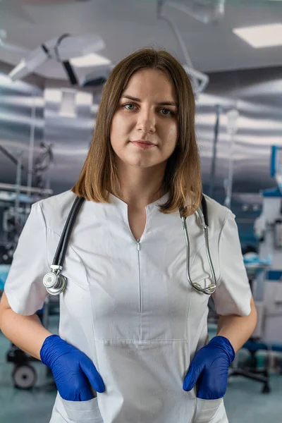 Młoda Piękna Lekarka Niebieskim Płaszczu Trzymająca Stetoskop Tabletki Ręku Stojąc — Zdjęcie stockowe