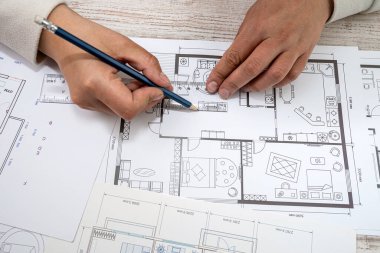 young man sitting according to the drawings of a new house project. Drawing concept