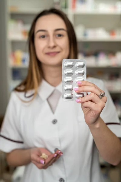 A female pharmacist checks the shelves for the presence of drugs. Pharmacy and pharmacist concept