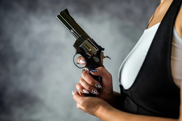 スタジオの暗い背景に黒い服を着た黒人の銃を持った若い女性 危険な女武装した女 — ストック写真
