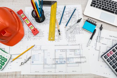 Masasında kask ve iş aletleri olan ev projesi planı. endüstriyel kavram