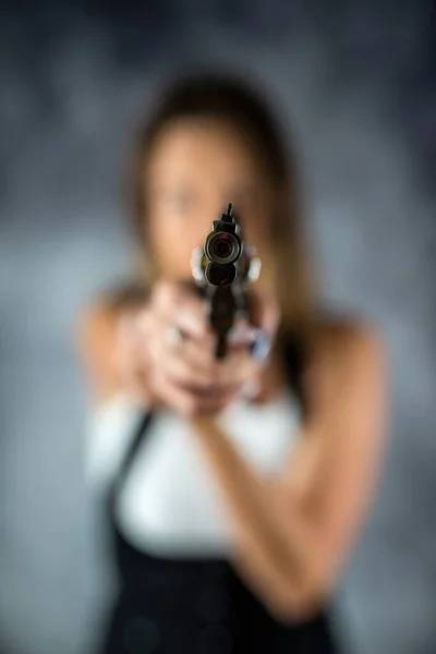 被害者に銃を向けた美しいブルネットのセクシーな女性 邪悪な女だ 危険な女は女の手に武器を — ストック写真