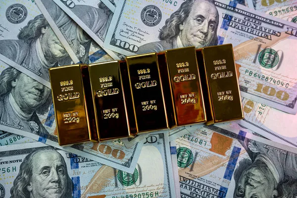 gold bars lie with a calculator near a large sum of dollars isolated. Concept of financial savings. gold and dollars.