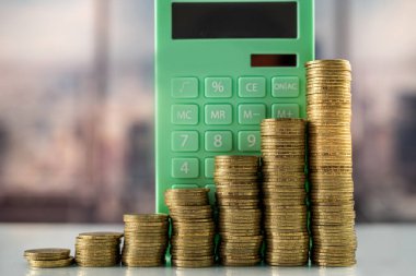 Hesap makinesiyle cam bir masanın üzerinde bir yığın bozuk para. İş için. Enflasyon. Doların büyümesi.