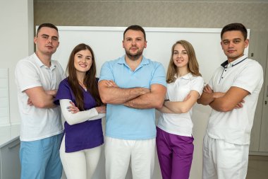 Güzel, genç, iyi giyimli dişçiler dişçi muayenehanelerinde güzel duruyor. Diş hekimleri ve portreleri kavramı