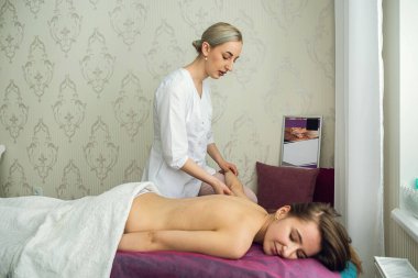 Pretty slim woman receiving a health massage treatment in a spa salon.  medical and relaxing massage.