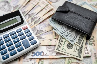 calculator with wallet on paper bills, Ukrainian hryvnias and us dollar exchange concept