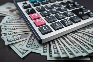Para dolarları ve hesap makinesi siyah arka planda izole edilmiş. Ekonomi konsepti. Para dağıtımı Euro. Dolar bazen düşer ve yükselir..