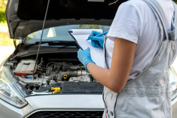 stock image beautiful female mechanic is working on a car breakdown at a car repair shop. woman car mechanic. tools in the hands of a woman