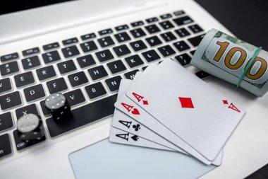 Dolar ve kumarhane zarları ve dizüstü bilgisayardaki kartlar siyah arka planda izole edilmiş. Kumar oynuyorum. kart oyunları konsepti