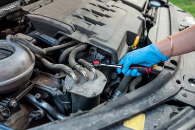 Tamirci, İngiliz anahtarı ve araba servisi ile araba tamirhanesinin motor tamirini yapıyor. onarım hizmetleri.